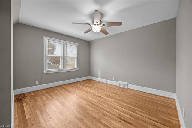 unfurnished room featuring visible vents, a ceiling fan, baseboards, and wood-type flooring