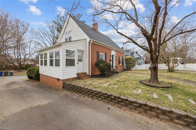 view of side of home with crawl space, entry steps, a chimney, and fence