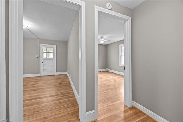 hallway featuring baseboards and wood finished floors