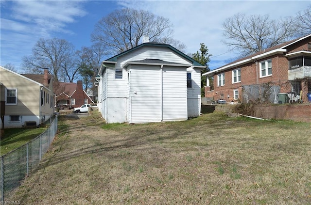 rear view of house with central air condition unit, a yard, fence, and a residential view