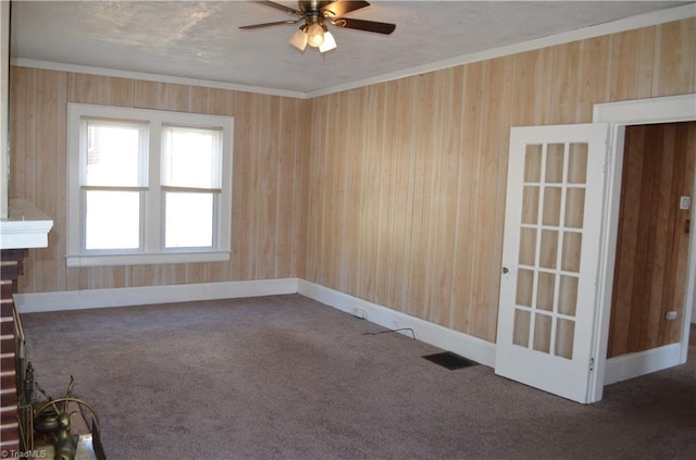 spare room featuring crown molding, carpet, visible vents, and baseboards