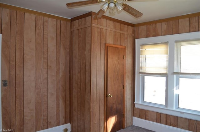 interior space with wooden walls and ceiling fan