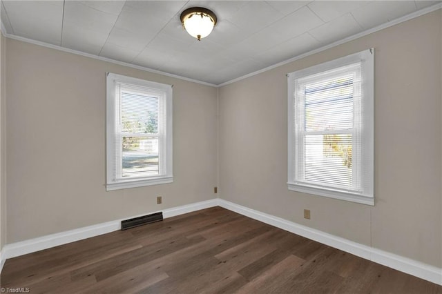 spare room featuring ornamental molding, dark hardwood / wood-style floors, and plenty of natural light