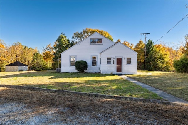 view of front of property featuring cooling unit and a front lawn