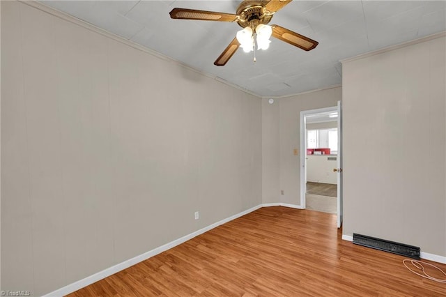 empty room with ornamental molding, light hardwood / wood-style flooring, and ceiling fan