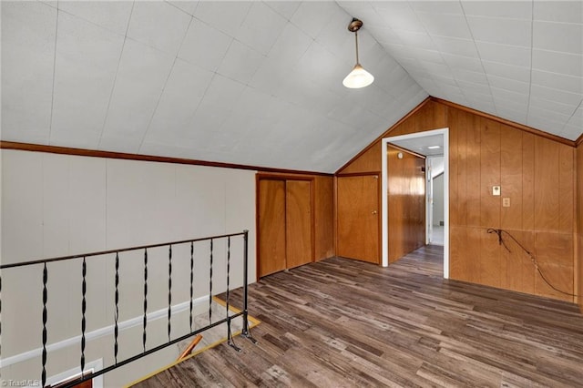 additional living space featuring lofted ceiling, wood-type flooring, and wood walls