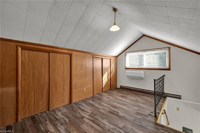 additional living space with light hardwood / wood-style floors, a wall unit AC, a baseboard radiator, and vaulted ceiling