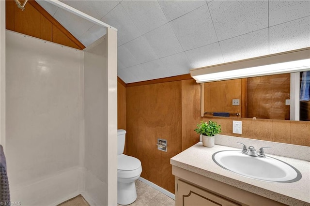 bathroom with vanity, toilet, wood walls, and walk in shower