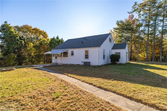 view of side of home with a yard and central AC unit