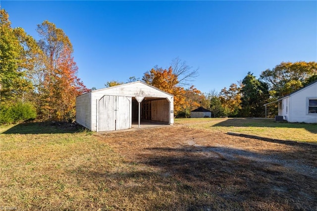 view of outbuilding featuring cooling unit and a lawn