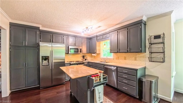 1721 Abbottsford Dr, Kernersville, NC 27284 - kitchen featuring stainless steel appliances, ornamental molding, butcher block countertops, a textured ceiling, and decorative backsplash