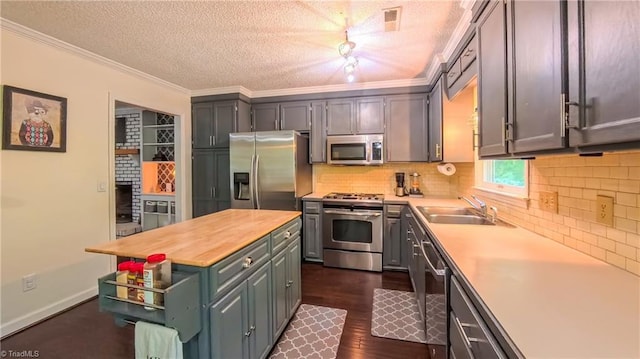 1721 Abbottsford Dr, Kernersville, NC 27284 - kitchen featuring stainless steel appliances, a center island, dark wood-type flooring, backsplash, and ornamental molding