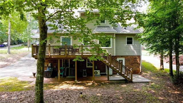 1721 Abbottsford Dr, Kernersville, NC 27284 - back of house featuring stairs, a deck, brick siding, and roof with shingles