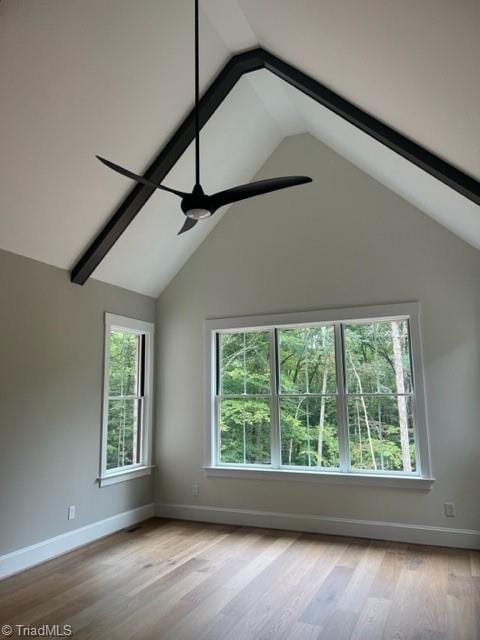 interior space with lofted ceiling with beams, ceiling fan, and light wood-type flooring