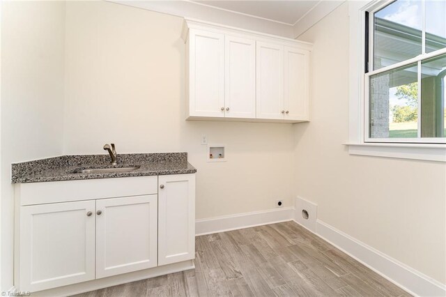 washroom featuring cabinets, washer hookup, ornamental molding, sink, and light hardwood / wood-style flooring