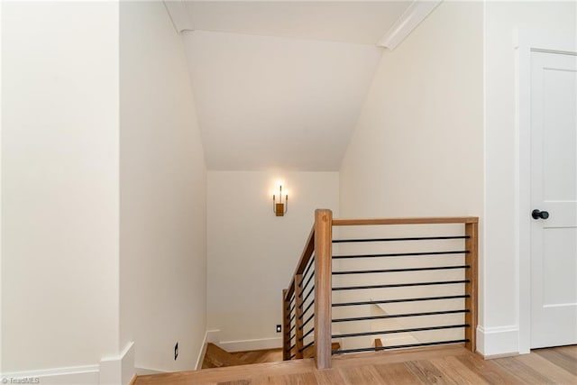 stairway featuring wood-type flooring and vaulted ceiling