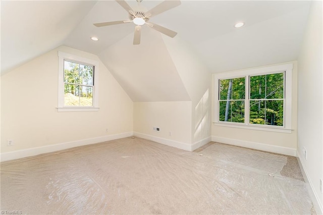 additional living space featuring light colored carpet, ceiling fan, and lofted ceiling