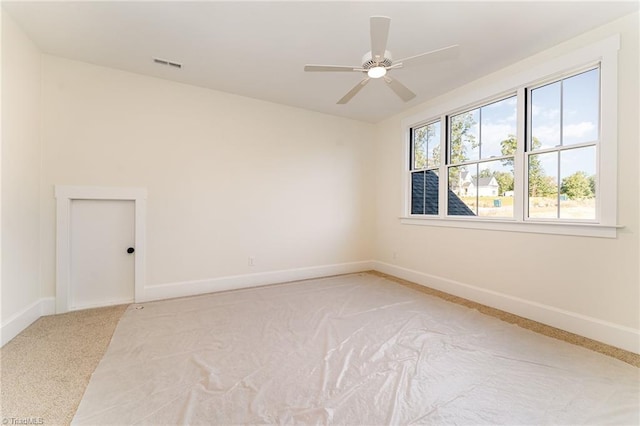 carpeted spare room with ceiling fan