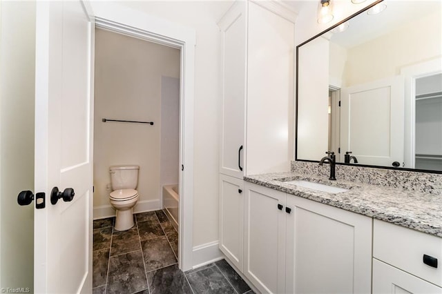 bathroom featuring a bath, vanity, and toilet