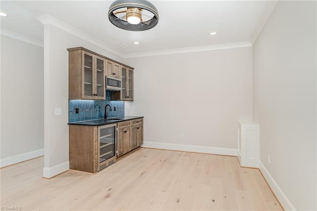 bar with wine cooler, crown molding, light hardwood / wood-style flooring, and sink