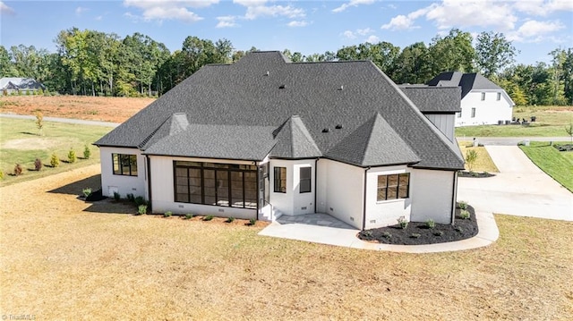 rear view of property featuring a lawn and a patio area