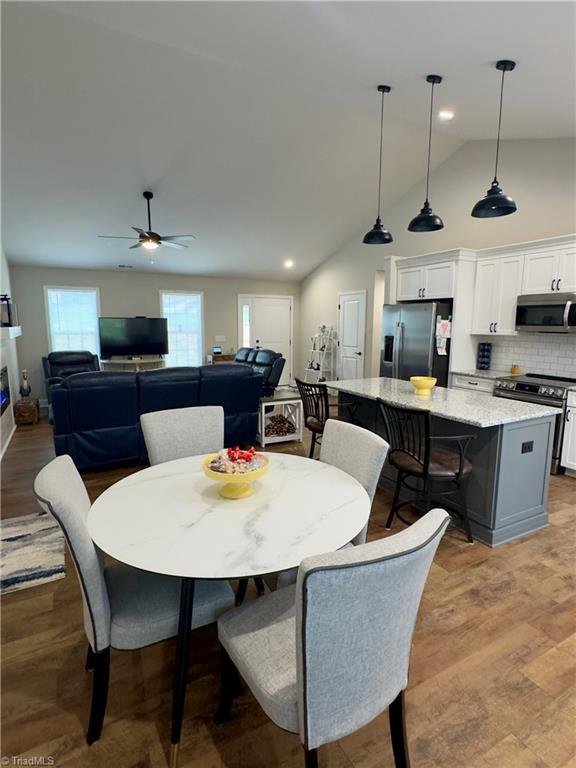 2968 Tobaccoville Rd, Tobaccoville, NC 27050 - dining area featuring high vaulted ceiling, recessed lighting, light wood finished floors, and ceiling fan