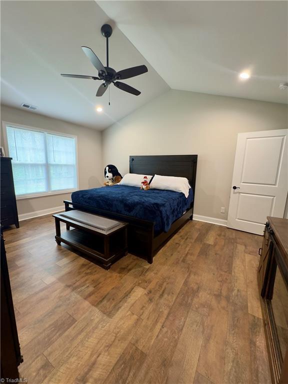 2968 Tobaccoville Rd, Tobaccoville, NC 27050 - bedroom with visible vents, baseboards, ceiling fan, vaulted ceiling, and wood finished floors
