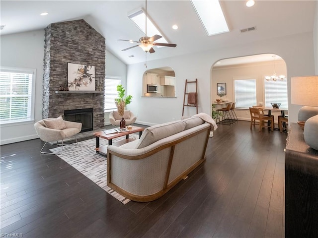 living room with vaulted ceiling, a healthy amount of sunlight, a fireplace, and dark hardwood / wood-style floors