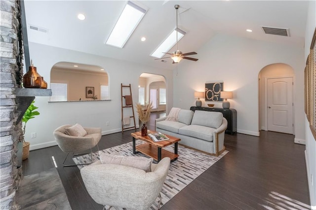 living room featuring vaulted ceiling, ceiling fan, dark hardwood / wood-style flooring, and a fireplace