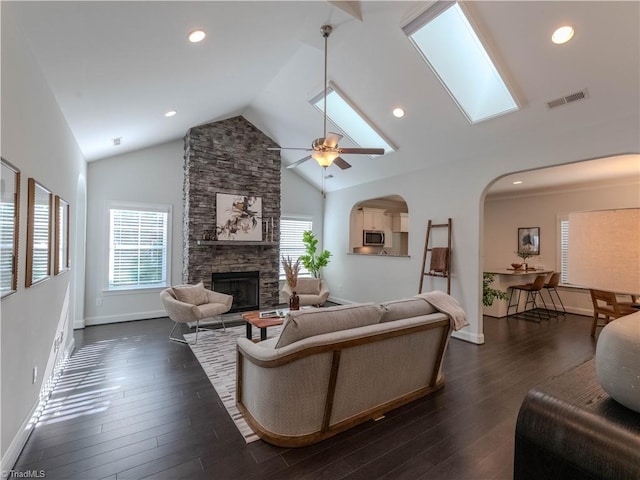 living room featuring dark wood-type flooring, lofted ceiling, a fireplace, and ceiling fan