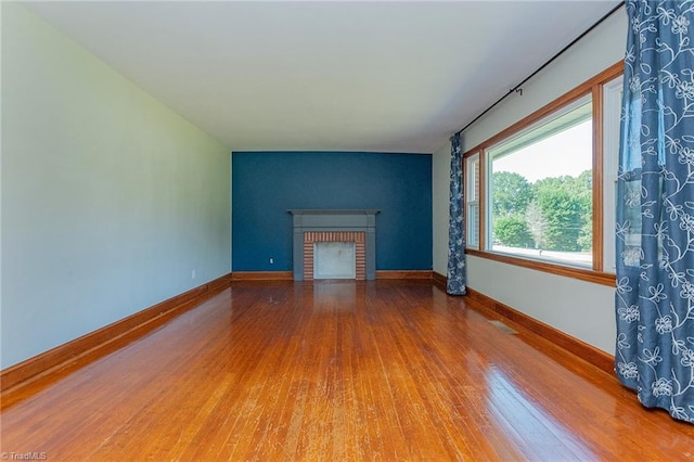 unfurnished living room featuring wood-type flooring and a fireplace