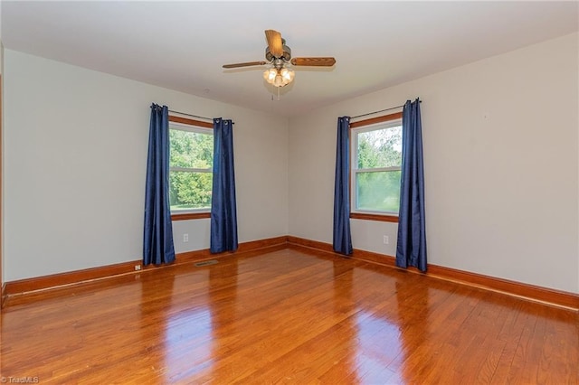 spare room with hardwood / wood-style floors, plenty of natural light, and ceiling fan