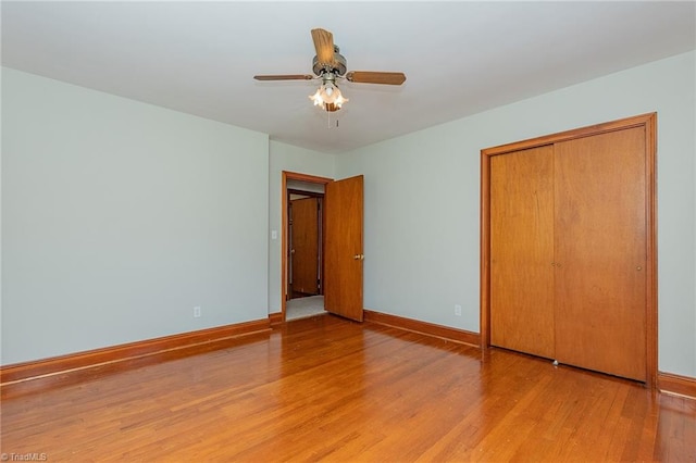 unfurnished bedroom with a closet, light wood-type flooring, and ceiling fan