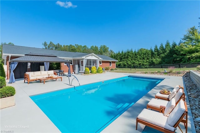 view of pool with outdoor lounge area, a patio, and a sunroom