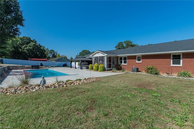 view of pool with central AC, a yard, a patio, and a sunroom