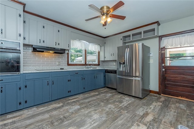 kitchen featuring appliances with stainless steel finishes, sink, backsplash, ceiling fan, and dark hardwood / wood-style floors