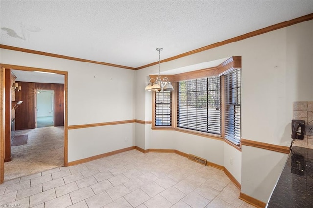 unfurnished dining area featuring light tile patterned floors, a textured ceiling, a chandelier, wood walls, and ornamental molding