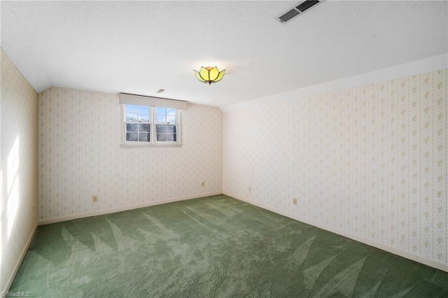 unfurnished room with vaulted ceiling and carpet