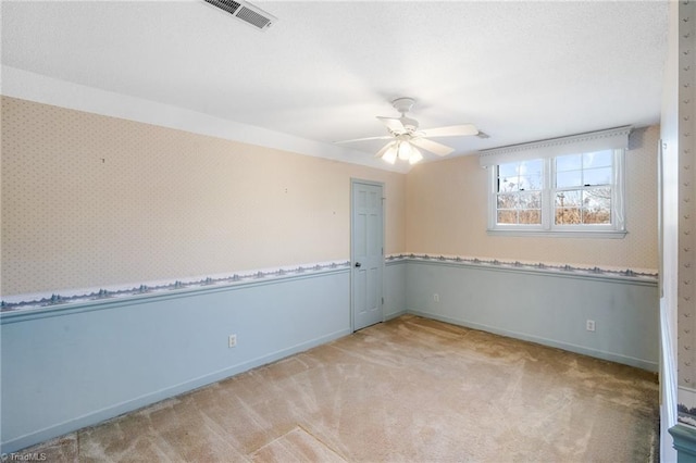 carpeted spare room with ceiling fan