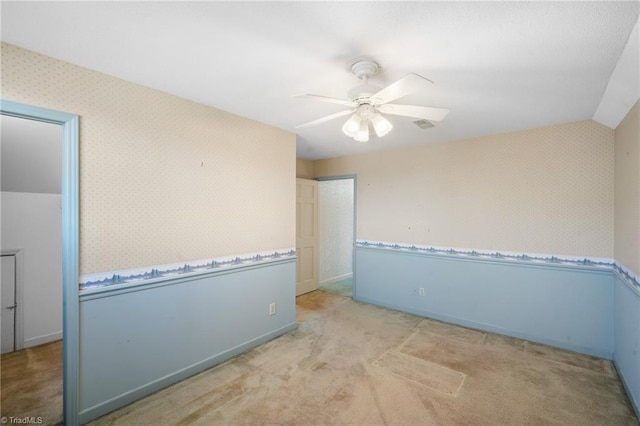 unfurnished room featuring light carpet, lofted ceiling, and ceiling fan