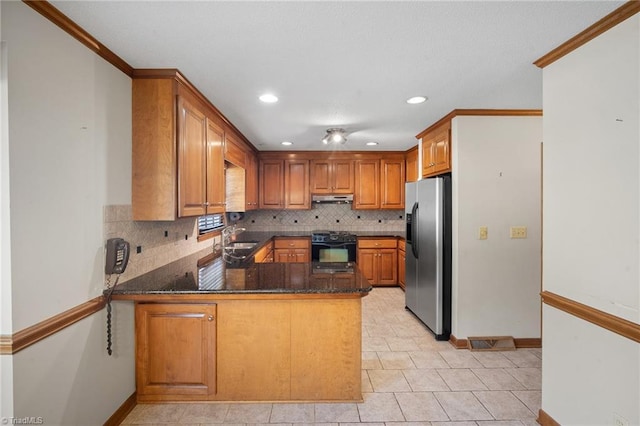 kitchen with black gas range, backsplash, sink, stainless steel fridge with ice dispenser, and kitchen peninsula