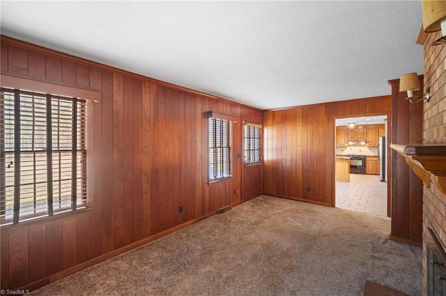 spare room featuring wood walls and light carpet