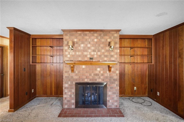 unfurnished living room featuring crown molding, wooden walls, built in shelves, and light colored carpet