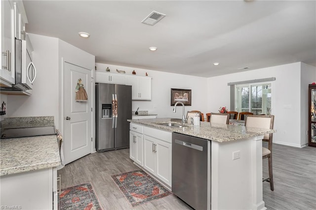 4997 Payne St, Trinity, NC 27370 - kitchen with stainless steel appliances, a sink, a breakfast bar, white cabinets, and recessed lighting
