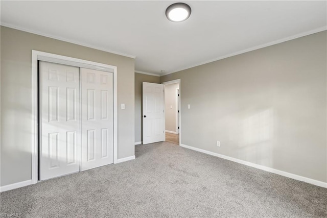 unfurnished bedroom featuring crown molding, carpet floors, and a closet