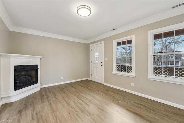 unfurnished living room featuring crown molding and light wood-type flooring