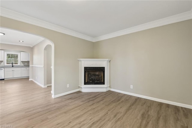 unfurnished living room with crown molding, sink, and light hardwood / wood-style flooring