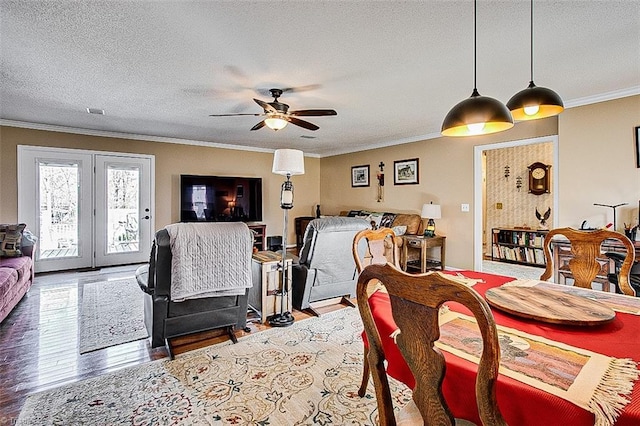 dining room with crown molding, a textured ceiling, and wood finished floors