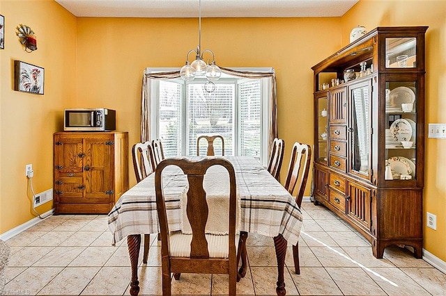 dining space featuring light tile patterned floors, baseboards, visible vents, and a notable chandelier