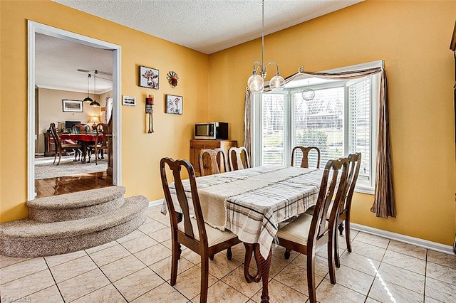 dining area featuring light tile patterned floors, baseboards, a chandelier, and a textured ceiling